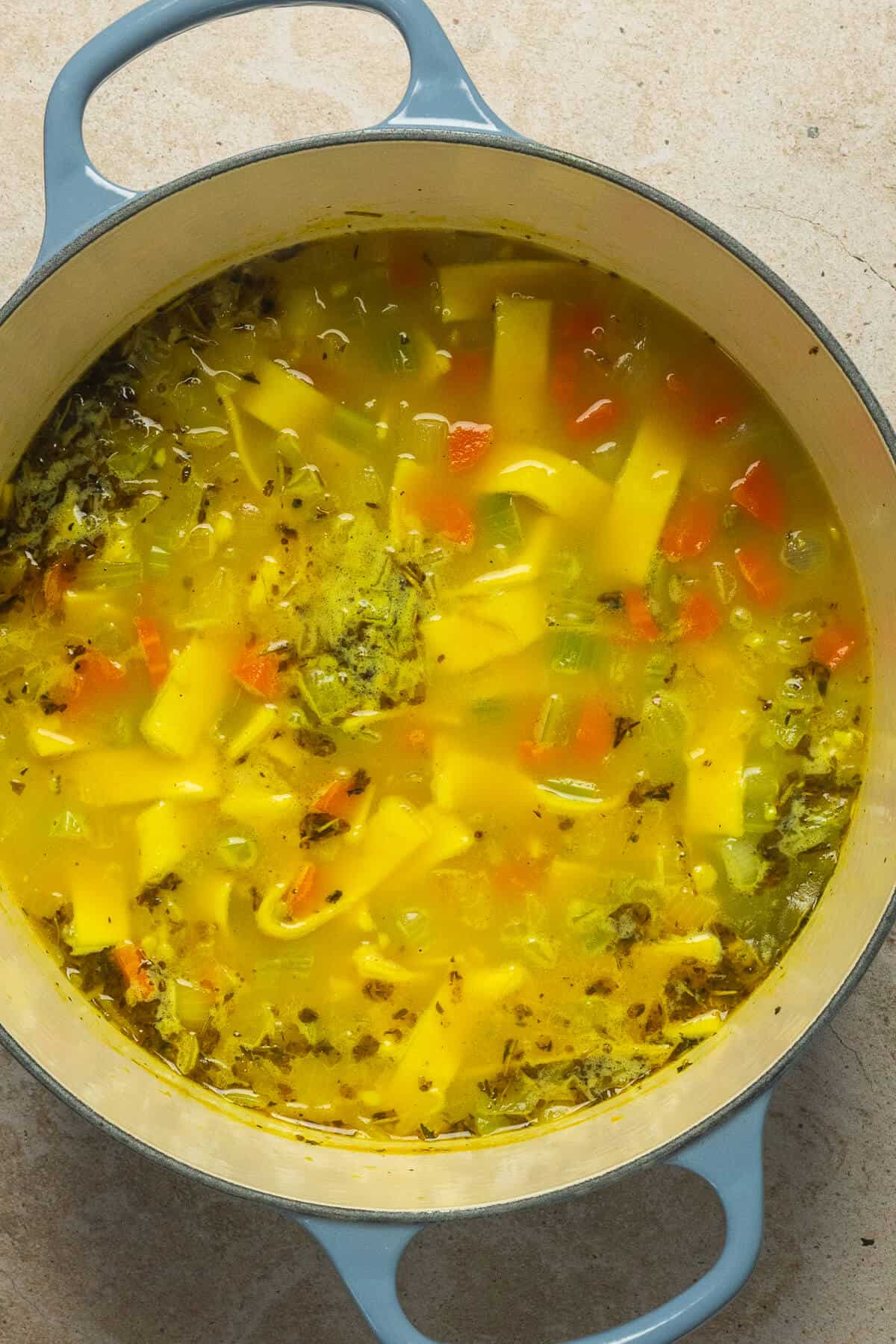 Noodles added to the large pot of chicken noodle soup.
