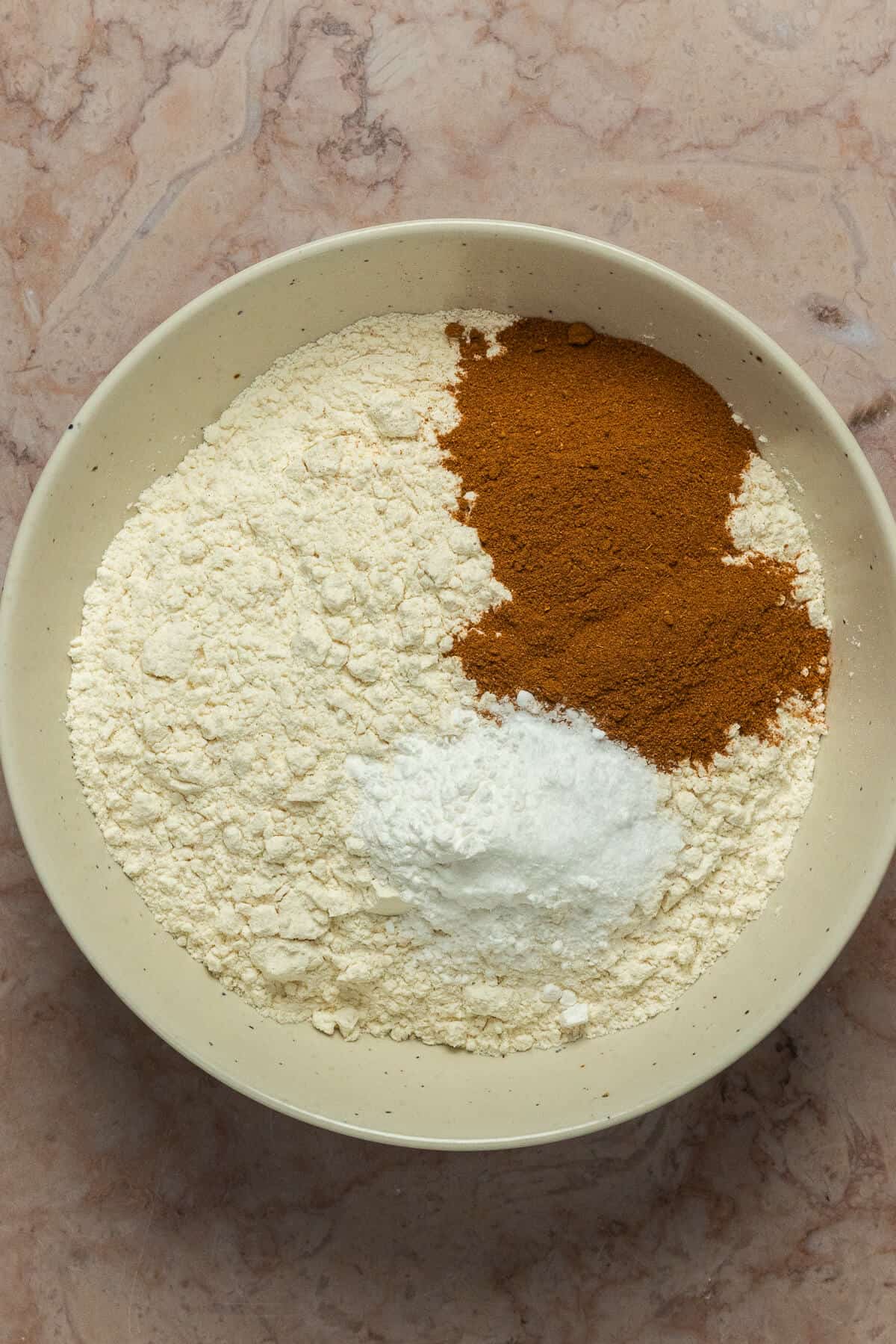 A bowl with the dry ingredients for the snickerdoodle cookies.